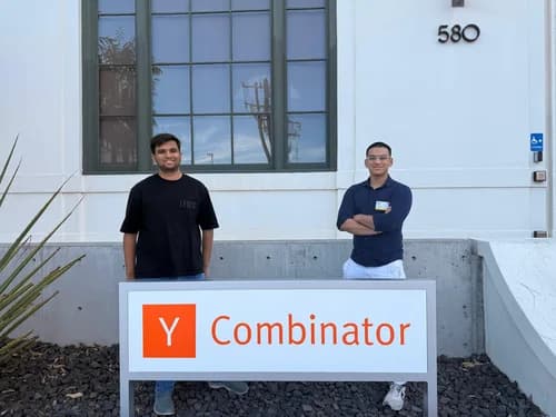 Agnay Srivastava and Pulkit Gupta standing behind the Y Combinator sign